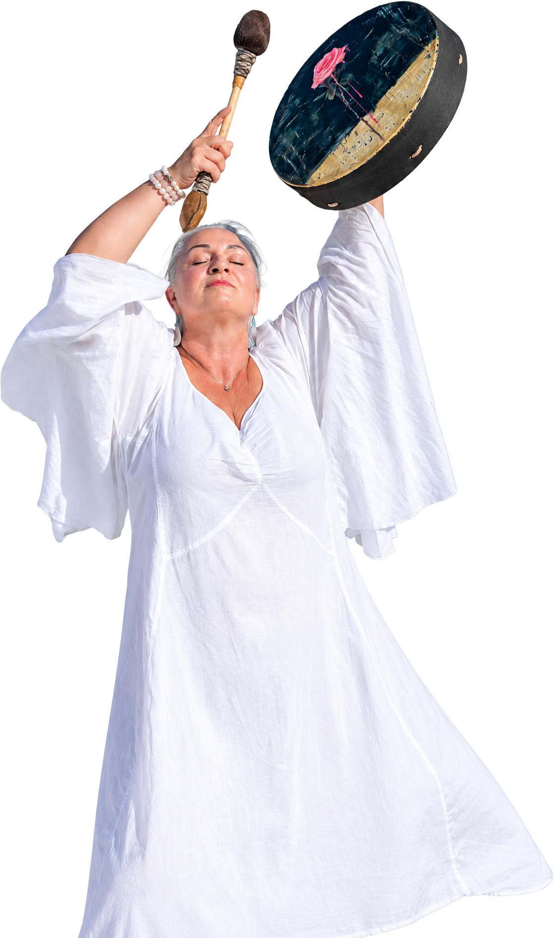 Joya Sosnowski with eyes closed and head tilted back, a rose-painted frame drum and mallet raised above her head